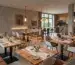 Stilvolle Restaurant Einrichtung mit verschiedenen Gastromöbeln wie massiven Holztischen, bequemen Polsterstühlen und modernen Stehtischen für ein ansprechendes Ambiente.