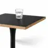 Schwarze Tischplatte des Cafétisch ARIOSO 68x68 cm mit natürlicher Schichtholzkante und Glas