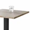 Cafétisch GIZA 68x68 cm mit heller Holzoptik-Tischplatte und schwarzem Mittelfuß im Gastronomiebereich