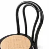 Detailansicht der gebogenen schwarzen Rückenlehne des Stuhl Wood Schwarz mit Rattan-Sitzfläche